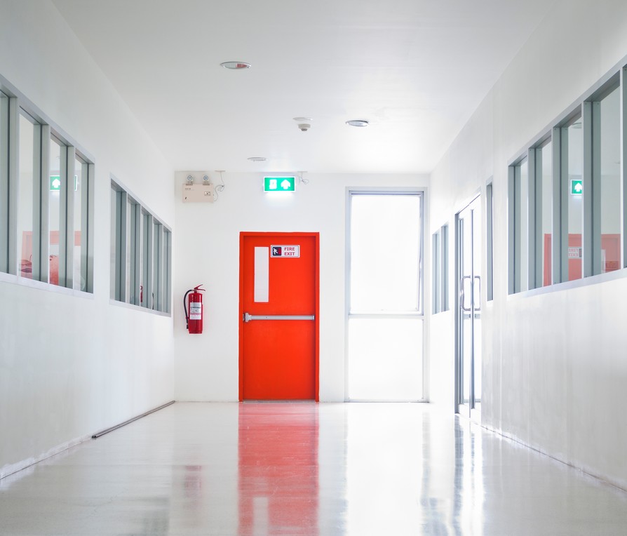Drzwi ewakuacyjne na końcu korytarza. Modernizacja przeciwpożarowa istniejących obiektów